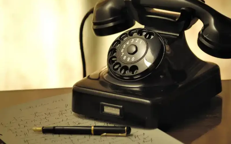 ein altes schwarzes Telefon mit Wählscheibe
